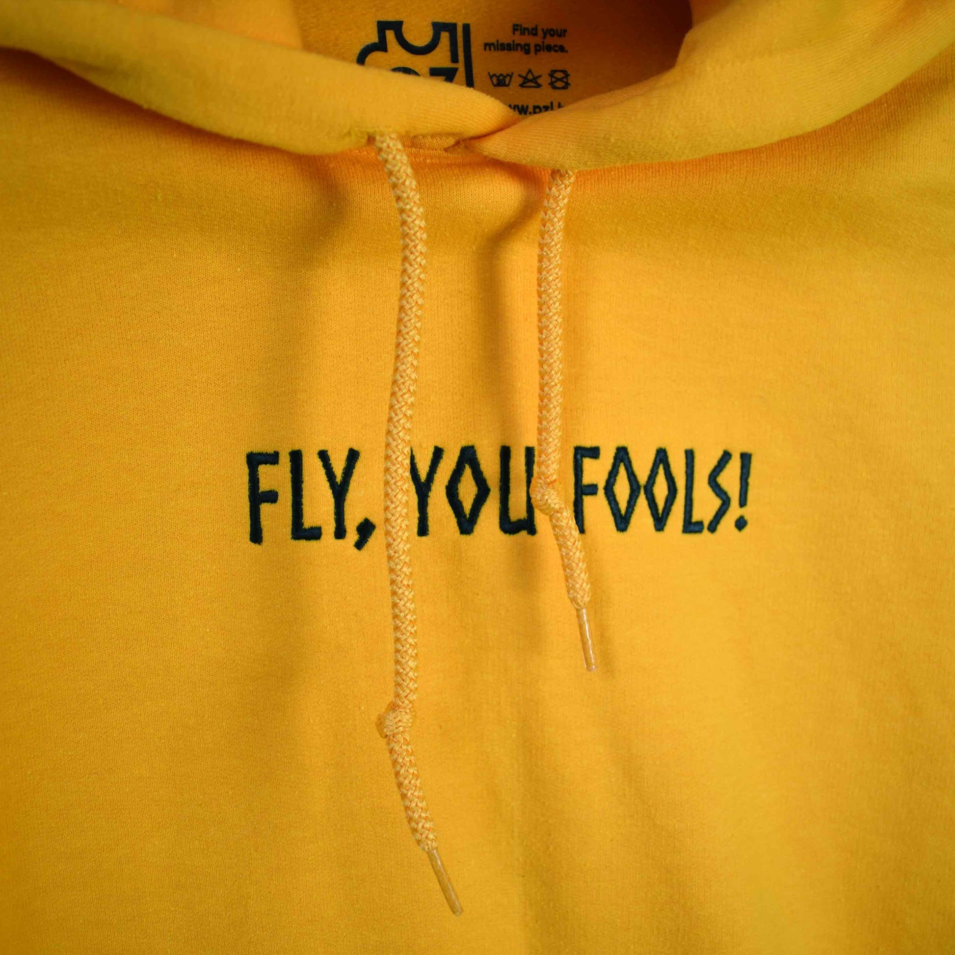 žuta hudica s vezom natpisa "Fly, you fools!"