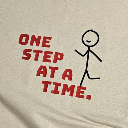 bež majica kratkih rukava s printom natpisa "one step at a time"